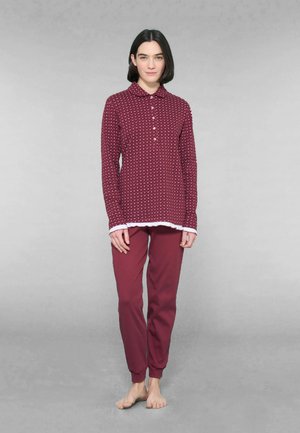 Set di pigiama bordeaux con top a maniche lunghe con bottoni, dotato di colletto e dettagli bianchi, abbinato a pantaloni tapered coordinati. Texture liscia.