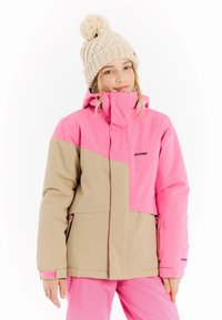 Rosa und beige Skijacke mit hohem Kragen, Reißverschlusstaschen und Logodetails. Beigefarbene Strickmütze mit einem Bommel oben.