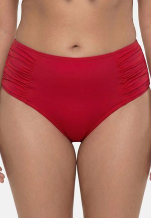 Czerwone bikini z wysokim stanem i marszczonymi bokami, noszone przez stojącą osobę, widoczne od talii do połowy uda.