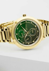 Goldfarbener Uhr mit grünem Ziffernblatt, drei Subdials, metallischen Akzenten und einem Gliederarmbanddesign. Quadratische Indizes und ein kreisförmiges Gehäuse.