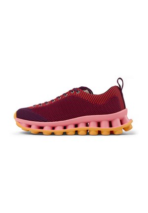 Zapatillas deportivas con parte superior de malla a rayas en tonos granate y rojo, entresuela rosa y suela exterior amarilla con un diseño segmentado único.
