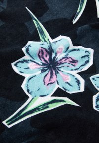 Tecido floral com grandes flores azuis com acentos em rosa sobre um fundo escuro. Superfície texturizada com cores vibrantes e contornos distintos.