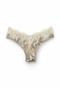 String en dentelle de couleur beige clair avec un motif serpent. Présente une délicate dentelle autour de la taille et un tissu au toucher doux.