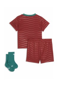 Maglietta rossa a maniche corte con motivo ondulato, colletto verde, pantaloncini rossi abbinati e calzini turchesi con dettagli bianchi. Tessuto morbido e leggero.