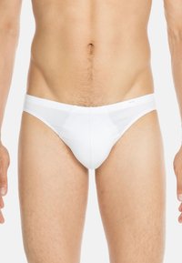 Weiße Herrenunterwäsche aus Baumwolle. Verfügt über einen weichen Bund und eine glatte Textur. Vorderteil mit Beutel-Design und minimale Bedeckung hinten.