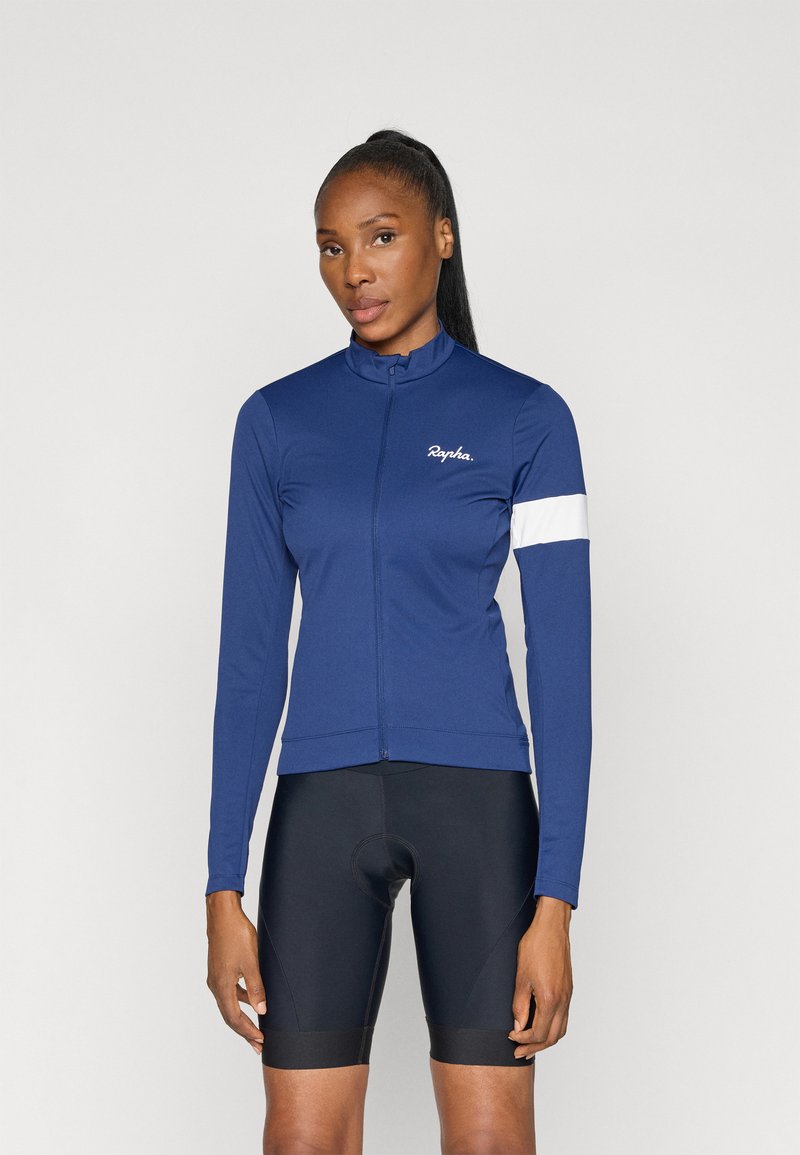 Jersey de ciclismo azul marinho com mangas longas e gola alta, apresentando uma faixa de destaque branca no braço esquerdo e um fecho com zíper na frente.