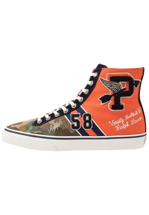Baskets montantes avec avant camouflage, arrière orange, lacets blancs, numéro 58, emblème P ailé et texte "varsity football" sur la semelle blanche.