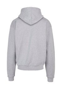 Sweat à capuche gris, fabriqué en matériau doux, affichant une coupe décontractée, des poignets et un ourlet côtelés, avec un design simple et dépouillé.