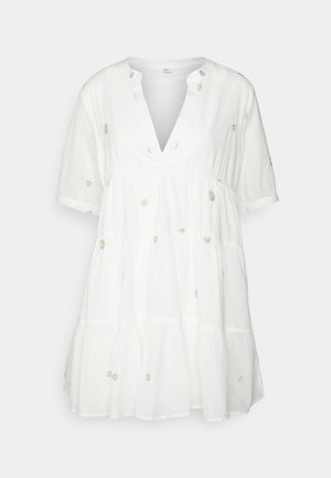 Robe blanche en coton avec un col en V, des manches courtes et un design à étages. Présente une petite broderie florale en bleu et jaune. Texture douce.