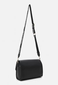 Borsa nera con lunga tracolla che presenta il marchio "Valentino". La borsa ha un design elegante e una forma strutturata.