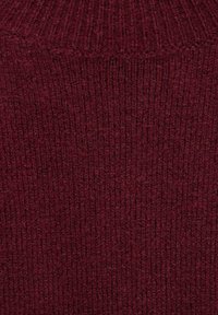 Bordeaux gestrickter Stoff mit einem strukturierten Rippenmuster und weicher, flauschiger Oberfläche.
