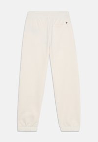 Cremefarvede sweatpants med elastisk talje og manchetter, enkelt baglomme og lille Tommy Hilfiger-logo over lommen.