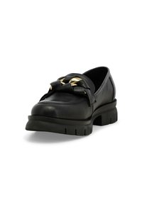 Mocassino in pelle nera con suola spessa e chunky, caratterizzato da un fiocco decorativo e accenti in oro sulla parte anteriore.