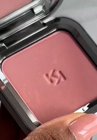 Kompakt rouge med myk rosa pudder. Har et reflekterende sølv-etui og en preget logo. Jevn tekstur, minimalistisk design.