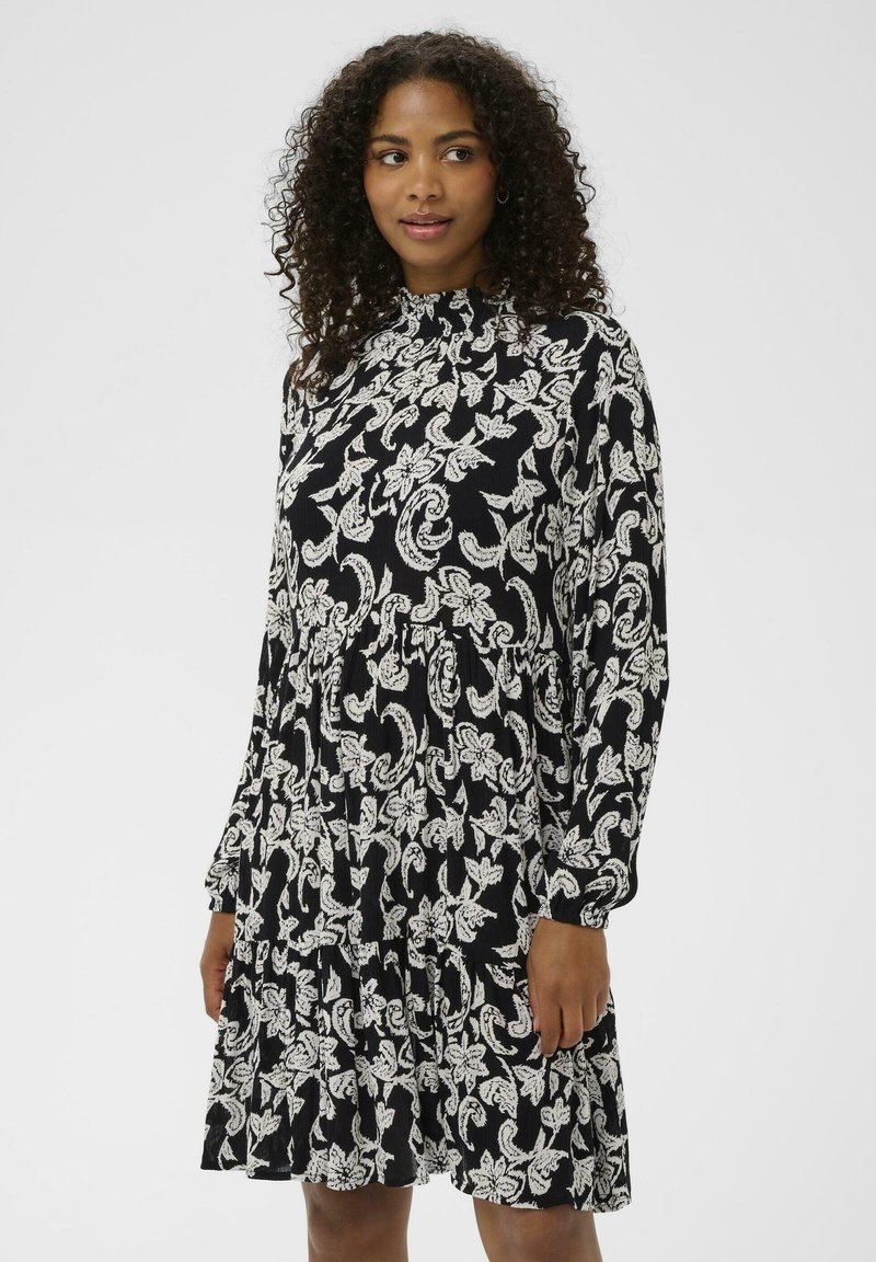 Must kleit valge lillelise paisleimustriga, pikad varrukad, kõrge kaelus ja kihiline seeliku disain, tehtud kerge ja tekstuurse kangaga.