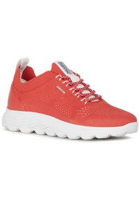 Baskets en mesh rouge respirant avec semelle blanche rembourrée et accents texturés. Dispose de lacets intégrés et d'un détail de logo sur le côté.