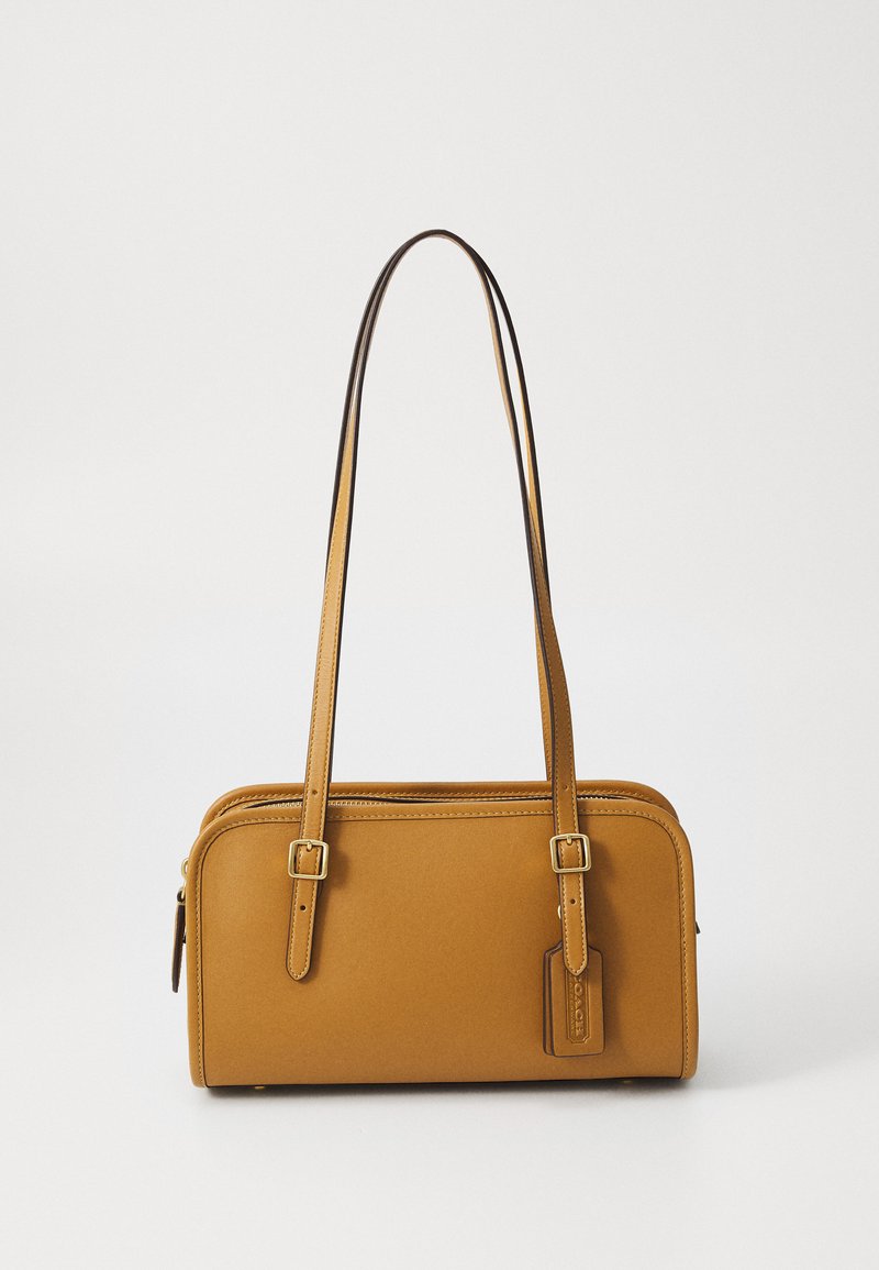 Tan leather handbag with a rectangular shape, two adjustable shoulder straps, and a small tag. Smooth texture with subtle stitching details.