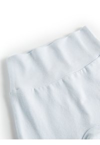 Leggings alto in vita di colore azzurro chiaro, realizzati in un morbido tessuto elastico con una texture liscia e cuciture arricciate in vita.
