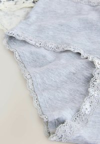 Grå bomulds-trusser med en delikat hvid blondekant langs kanterne, med en glat tekstur og et klassisk trusse-design.