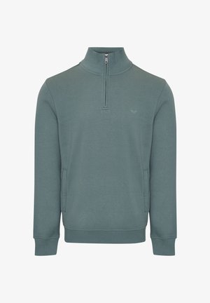 Lys teal pullover med en kvart lynlås, lange ærmer, sidelommer, ribbede manchetter og et diskret logo på brystet. Blød stoftekstur.