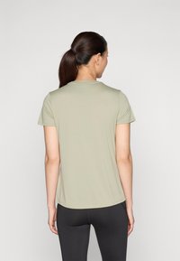 Ljusgrön t-shirt med kort ärm och rundad halsringning, tillverkad av ett mjukt och elastiskt material. Avslutad med en svängd nederkant.