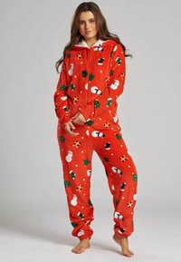 Pijama de forro polar rojo con cremallera, que presenta patrones navideños: Papá Noel, árboles y calcetines sobre una textura suave y acogedora. Mangas largas, puños elásticos.