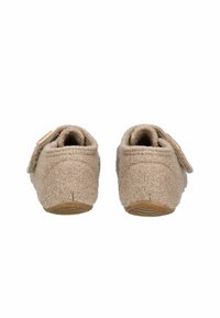 Beżowe wełniane kapcie z teksturowaną powierzchnią, okrągłym kształtem i rzepem. Posiadają gumową podeszwę oraz miękkie wyściółkę dla wygody.