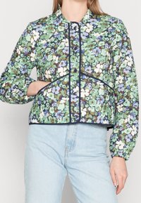 Gebloemd gewatteerd jack met een patroon in groen, blauw en wit; voorzien van een ronde halslijn, drukknopen en elastische mouwen.