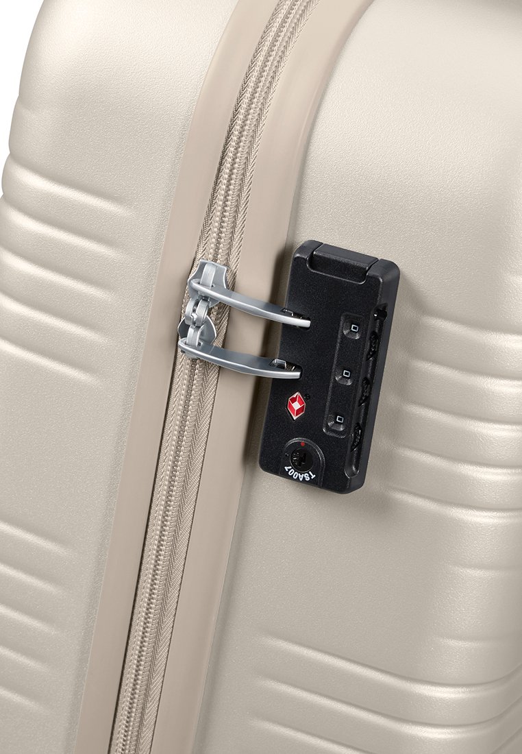 Valise rigide beige avec des rainures horizontales, dotée d'une fermeture éclair argentée et d'un cadenas noir à combinaison avec des lumières indicatrices.