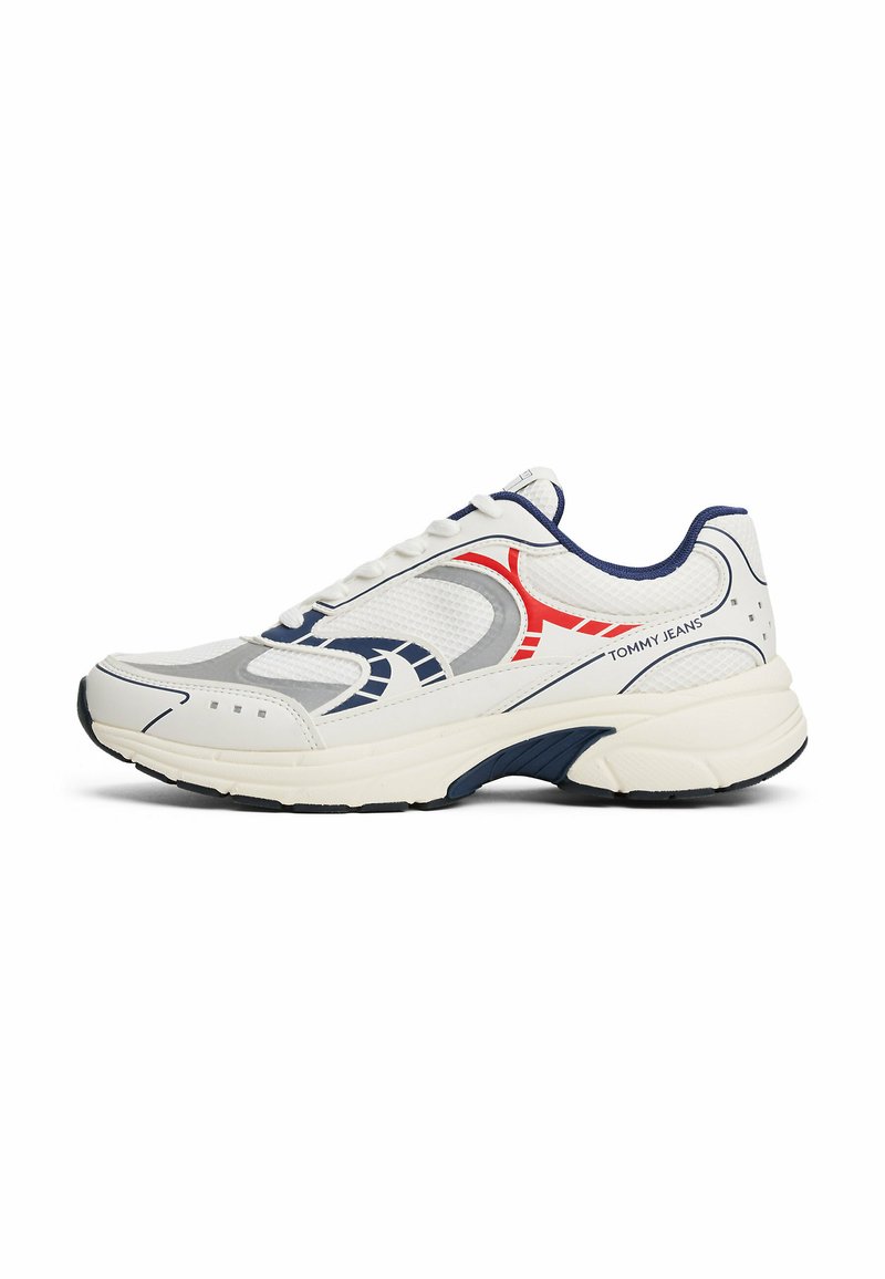 Scarpa sportiva bianca con accenti grigi, rossi e blu navy. Presenta una tomaia in rete, una soletta imbottita e cuciture dettagliate lungo i lati.