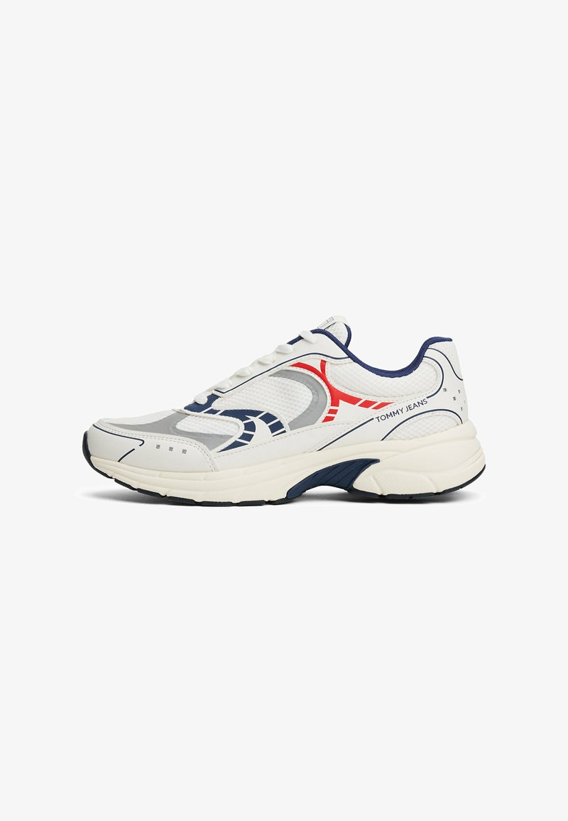 Scarpa sportiva bianca con accenti grigi, rossi e blu navy. Presenta una tomaia in rete, una soletta imbottita e cuciture dettagliate lungo i lati.