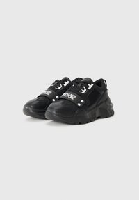 Sorte sneakers med et klodset design, der har en blanding af glat læder og mesh-materiale, hvide logo-detaljer og runde snørehuller.