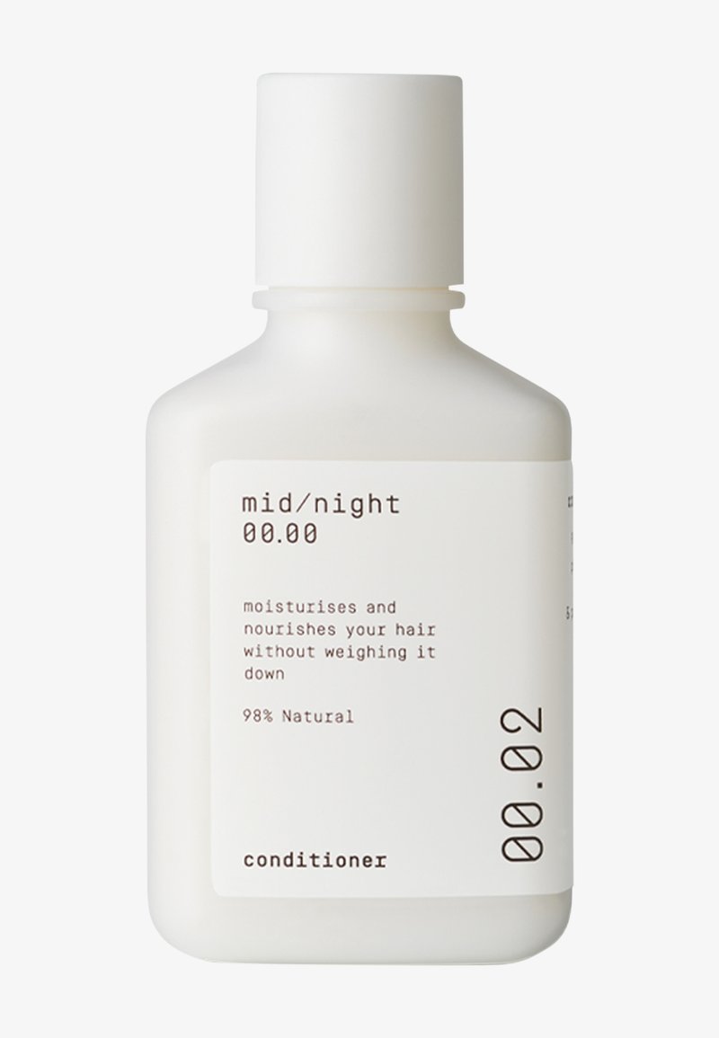 Flacon blanc à presser avec un corps rond et un couvercle à bascule. L'étiquette présente un texte noir détaillant un après-shampoing hydratant, 98 % naturel.