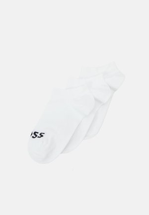 Chaussettes blanches de cheville en mélange de coton, avec une texture douce et un détail de logo noir sur le côté. Pack de trois.