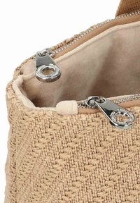 Bolso de yute beige con un acabado texturizado, que presenta un cierre de cremallera plateada y un forro interior suave.