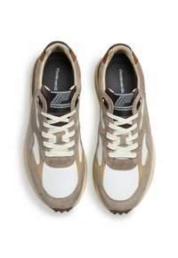 Zapatillas de ante beige y cuero blanco con un acabado texturizado, que cuentan con cordones crema, una etiqueta de logo negra y una suela de goma de color claro.