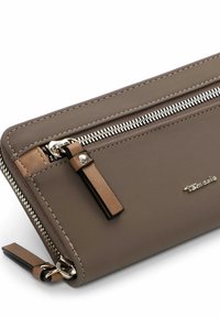 Brown zippered wallet made of smooth, durable material. Features silver zipper, leather accents, and a small logo. Flat design for easy carrying.
