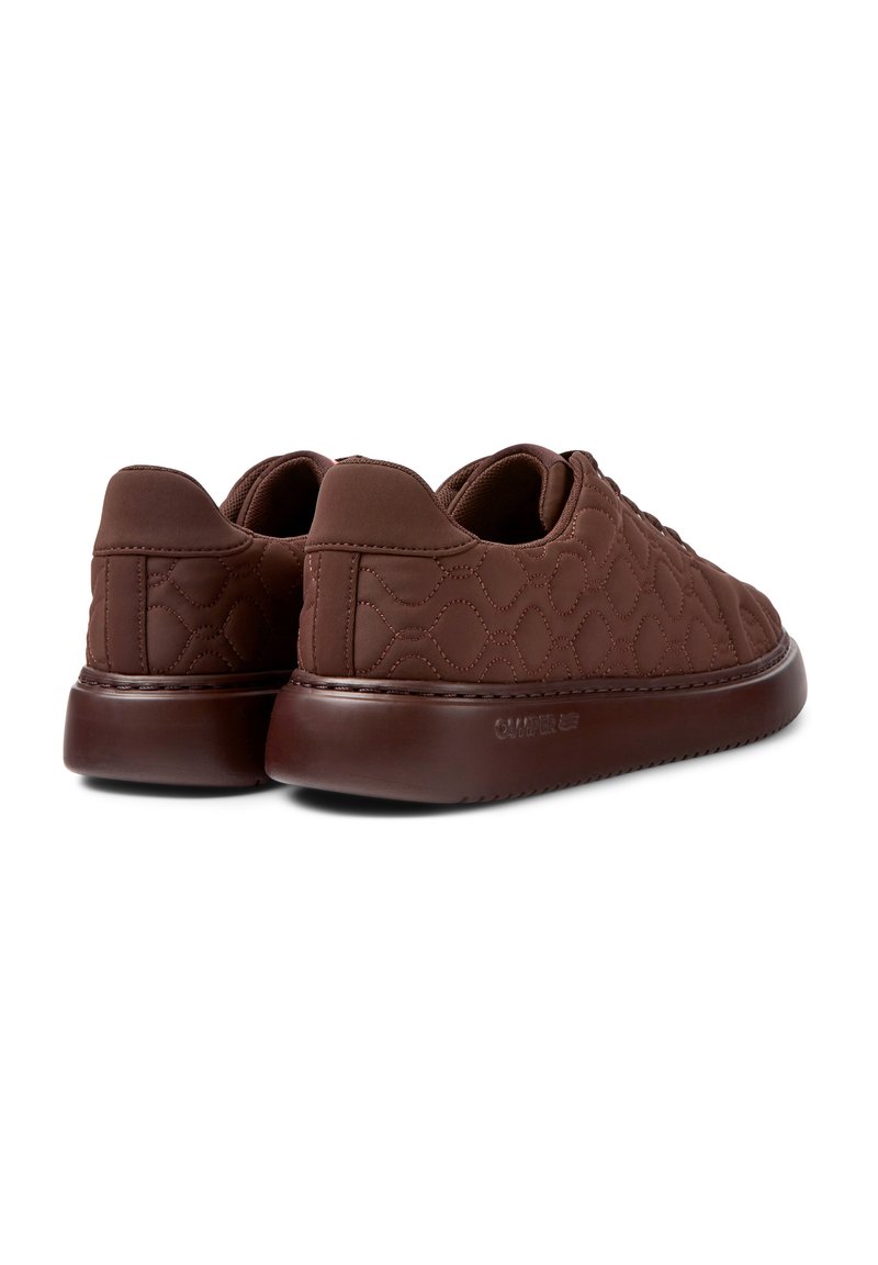 Sneaker marroni trapuntati con suola in gomma liscia, forma arrotondata e dettagli di cucitura tono su tono sulla tomaia e sul tallone.