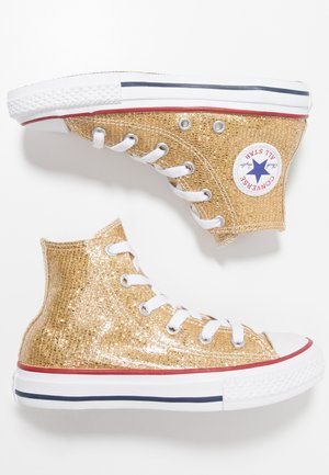 Para złotych brokatowych tenisówek Converse typu high-top z białymi sznurowadłami, białymi gumowymi podeszwami oraz czerwono-granatowymi paskami.