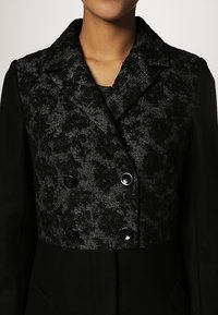 NAF NAF Klassisk kappa / rock - black