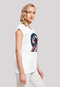 White cotton t-shirt with a round neck and rolled sleeves, featuring a colorful graphic design of "The Who" and the British flag.