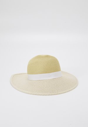 Solhat med bred skygge i strå med en lys beige krone og et hvidt bånd omkring bunden, sat op imod en ensfarvet hvid baggrund.