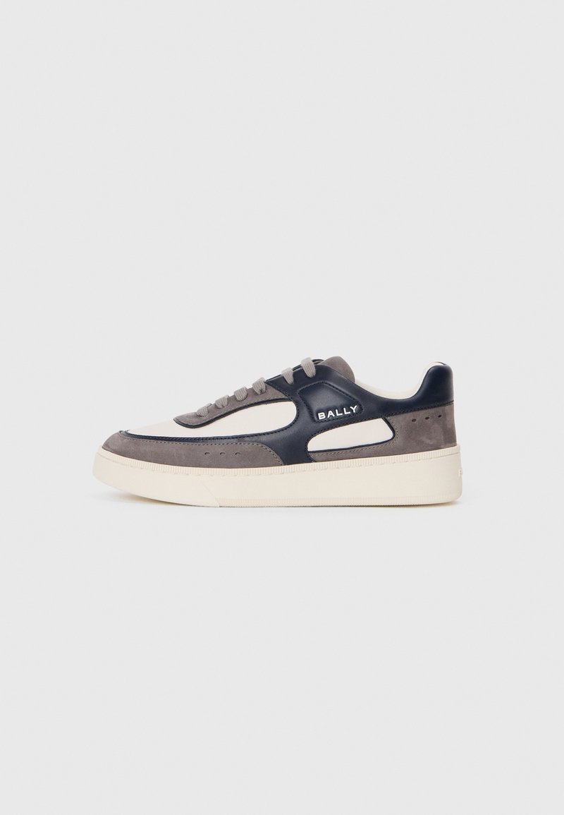 Adidași gri și bleumarin cu un exterior din piele netedă, accente din suede, talpă din cauciuc bej și sistem de închidere cu șireturi. Prezintă un logo pe lateral.