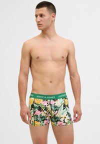 Bunt gemusterte Boxershorts mit einem tropischen Blumenmuster, ausgestattet mit einem grünen Bund mit "JACK & JONES" Branding.