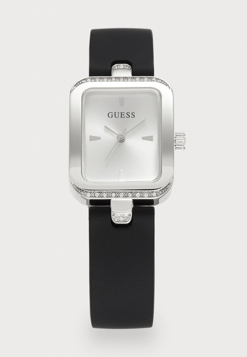 Square silver Guess wristwatch with crystal accents, minimalist dial, and black silicone strap.