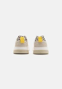 Beige sneakers with a textured leopard print upper, yellow heel tab, and white sole. "GIOSEPPO" logo on the heel.