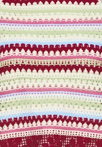 Farebná háčkovaná tkanina so striedavými radmi slučiek a oblúkov v červenej, ružovej, zelenej, bielej a modrej priadzi.