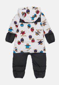 Tutina imbottita per bambini in bianco e nero con un motivo di orsi che indossano giacche e cappelli invernali colorati.