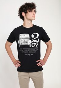 Svart bomullst-shirt med en vintage bilgrafik och texten "2 CV AUTHORIZED REPAIR SERVICE" i sliten vit tryck.