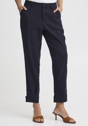 Morskie lniane spodnie o luźnym kroju, wyposażone w boczne kieszenie, mankiety z guzikami oraz gładką fakturę.